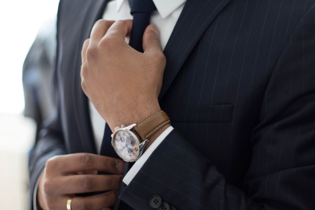 Dlaczego prawnicy tak dużo zarabiają? Zdjęcie przedstawia mężczyznę w garniturze z drogim zegarkiem