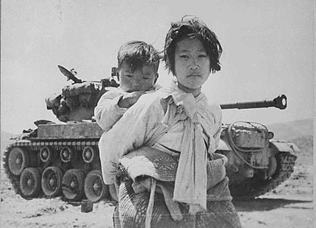 Dlaczego Związek Radziecki wspierał wybuch wojny koreańskiej w 1950 roku? Zdjęcie przedstawia koreańską kobietę z dzieckiem na tle czołgu